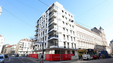 Außenansicht vom Gemeindebau Neu in der Schönbrunnerstraße. Das Foto zeigt eine Ansicht vom 5 mit Bilick in Richtung 6. Bezirk, es sind zwei Seiten des Gebäudes erkennbar, es gibt zahlreiche Balkone