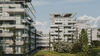 Visualisierung eines Wohnprojekts mit weißer Fassade und vertikaler Begrünung