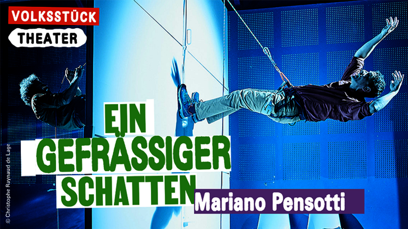 Das Bild zeigt das Plakat der Stückes "Ein Gefräßiger Schatten" der Wiener Festwochen - Volksstück Theater. Der Titel sowie der Name des Regisseurs Marina Pensotti sine darauf zu lesen. Das Bild selbst zeigt einen Szenenausschnitt bei dem die beiden Schauspieler mit einem Seil jeweils auf einer Seite einer Wand hängen und sich mit den Beinen von dieser wegstemmen.